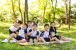 © Blue Jean Images - Cheerful school children picnicking outdoors with their teacher