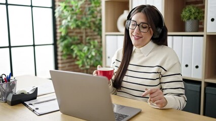 Poster - Young beautiful hispanic woman business worker listening to music drinking coffee at office