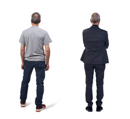 back view of the same man standing and dressed in a suit and casual clothing on white background