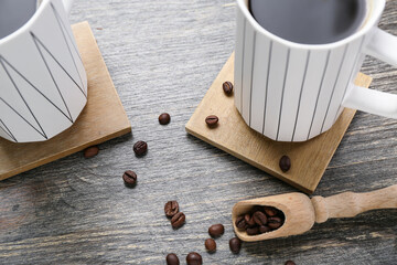 Wall Mural - Drink coasters with cups of coffee and beans on wooden table