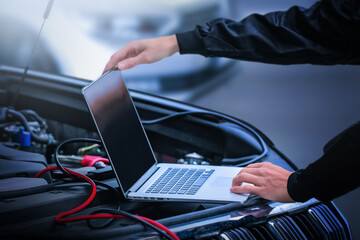 computer diagnostics of the car in garage. automotive mechanical technician using laptop computer pr