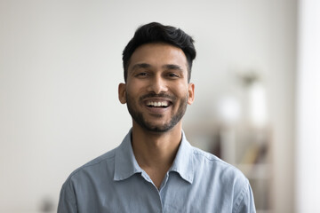 Happy handsome young Indian man head shot front portrait. Cheerful successful entrepreneur, startup leader, business professional in casual looking at camera with toothy smile