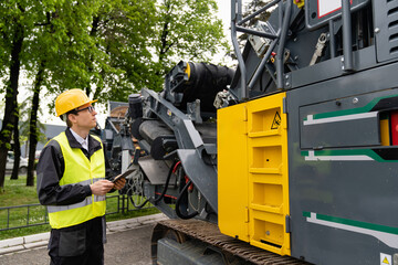 Aufkleber - Engineer with digital tablet next to road construction machine.
