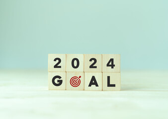 Wall Mural - 2024 goals of business or life. Wooden cubes with 2024 and goal icon on smart background. Starting to new year. Business common goals for planning new project, annual plan, business target achievement