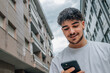 © carballo - young man on the street looking at the mobile phone or smartphone