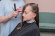 © KatrinaQQ - portrait of a child in a barber shop or beauty salon, a happy girl gets a haircut in a beauty salon