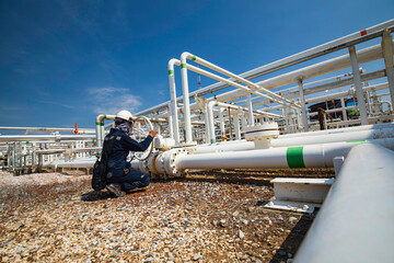 Canvas Print - Production operator opening ball valve at pipeline oil and gas wellhead remote platform to control gases and crude oil process petroleum