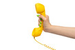© Nikolay - Yellow handset in woman hand with green nails isolated on a white background.