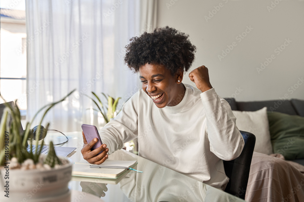Excited African American teen student feeling excited winner holding ...