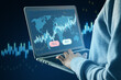 © Who is Danny - Close up of male hand using laptop with glowing blue sell and buy buttons, map and candlestick forex chart on blurry background. Trading and exchange concept.