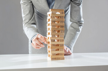 Wall Mural - Businesswoman removing wooden block from tower