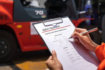 Wall Mural - a mechanical engineer is using heavy equipment checklist form for inspecting the factory forklift ve