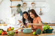 © Art_Photo - Portrait of enjoy happy love asian family mother with little girl daughter child help cooking food healthy eat with vegetable testing smell soup in pot with spoon.helping mommy in kitchen at home