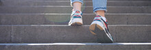 Woman Legs In Jeans And Sneakers Going Up Steep Stairs
