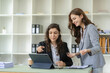 © ArLawKa - Businesswoman and accountant talking with laptop and tablet Two attractive millennial caucasian businesswoman planning project together at table in office