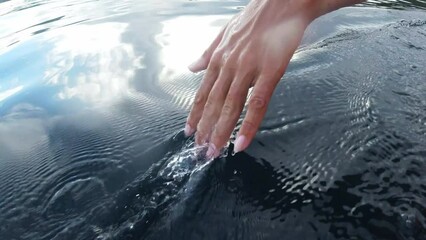 Poster - Closeup ocean, holiday and hand in water for happiness, relax and feeling the sea. Earth, relaxing and person touching a river or lake on a vacation by the beach with fingers for leisure and carefree