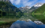 Fototapeta  - Wandern in Österreich, nahe dem Allgäu: der schöne Bergsee Vilsalpsee in den Tannheimer Bergen in Tirol mit Angler und Boot später Frühling, früher Sommer im Mai
