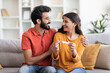 © Prostock-studio - Happy indian couple holding positive pregnancy test and embracing at home