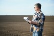 © Serhii - A farmer checks quality of soil before sowing.