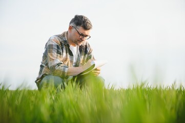 Experienced and confident farmer on his field. Portrait of senior farmer agronomist in wheat field.