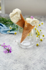 Wall Mural - Homemade vanilla ice cream scoops in cones on table with summer flowers