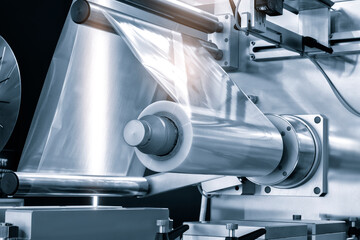 Poster - Automatic industrial machine for plastic packaging with light effect of products and food. shaft of an automated packaging line with plastic film in a light blue scene. product packaging concept