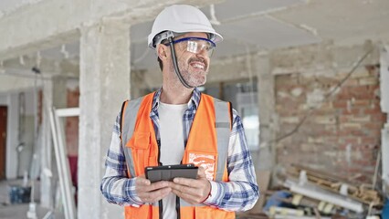 Sticker - Middle age man builder smiling confident using touchpad at construction site