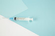 Close up view of disposable syringe on blue white background with free space