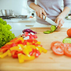 Wall Mural - Closeup on young woman slicing vegetables