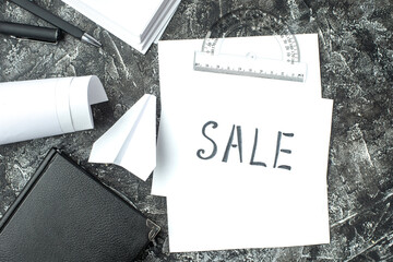 Wall Mural - overhead view of white sheet with sale writing and notebook ruler pens blanks paper plane on gray di