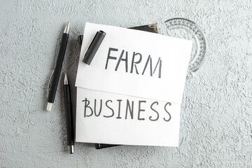 Wall Mural - top view of business and farm writings on white sheets ruler pens on gray sand background with free 