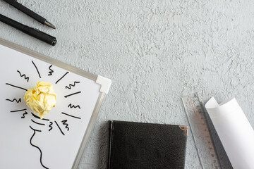 Wall Mural - top view of incompletely drawn thing and crushed wrapped paper on white desk notebook ruler on gray 
