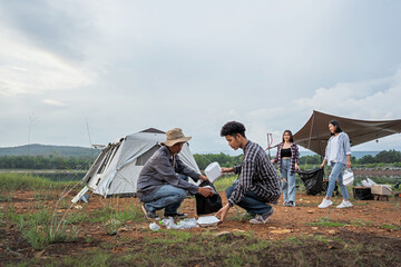 a group of tourists camping by the river and the forest, collecting trash around the camp site, to r