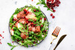 Healthy useful salad with grilled chicken liver, green apple, pomegranate seeds and fresh arugula. White kitchen table background, top view
