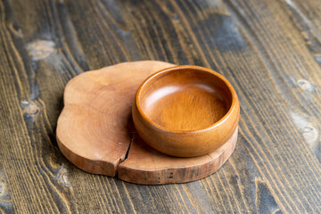 Wall Mural - Wooden bowl on wooden table, empty round bowl for groceries and food