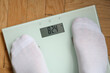 Odchudzanie, mężczyzna stojący na elektronicznej wadze do pomiaru masy ciała 