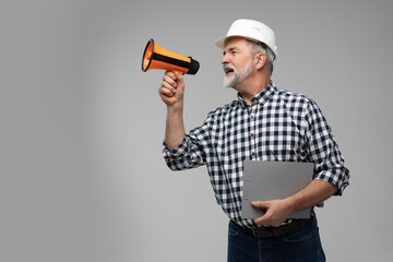 Wall Mural - Builder shouts into megaphone. Mature man builder is holding megaphone