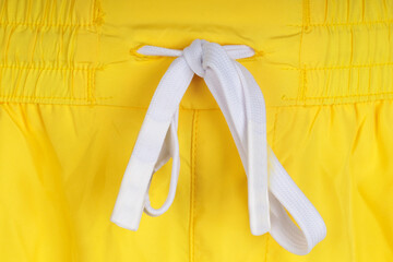 Close-up of knot on shorts. Detailed yellow short