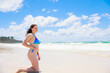 © photok - 大海原の前で膝立ちするオーストラリア人少女