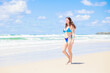 © photok - ビーチを歩く水着姿の外国人女性