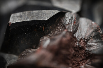 Metallic rock texture. Close up of a raw hematite stone. Black mineral with an abstract texture.