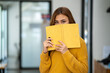 © Wuttichaik - Young Beautiful smiling happy student woman wearing headphone holding a book, Portrait of student girl carry book balancing books on head and hand