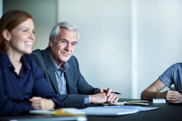 Wall Mural - Senior businessman listening in meeting