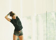 © KOTO - Fit woman stretching arm in gym studio mirror