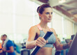 Focused woman exercising on elliptical trainer in gym