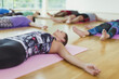 © KOTO - Serene woman in corpse pose in yoga class
