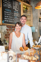 Wall Mural - Portrait smiling cafe owner couple behind the counter