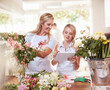 Florists with digital tablet arranging bouquet in flower shop