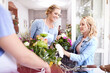 Florist helping woman pick out flowers in flower shop