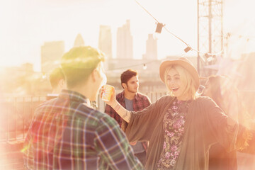 Wall Mural - Enthusiastic young adults enjoying rooftop party